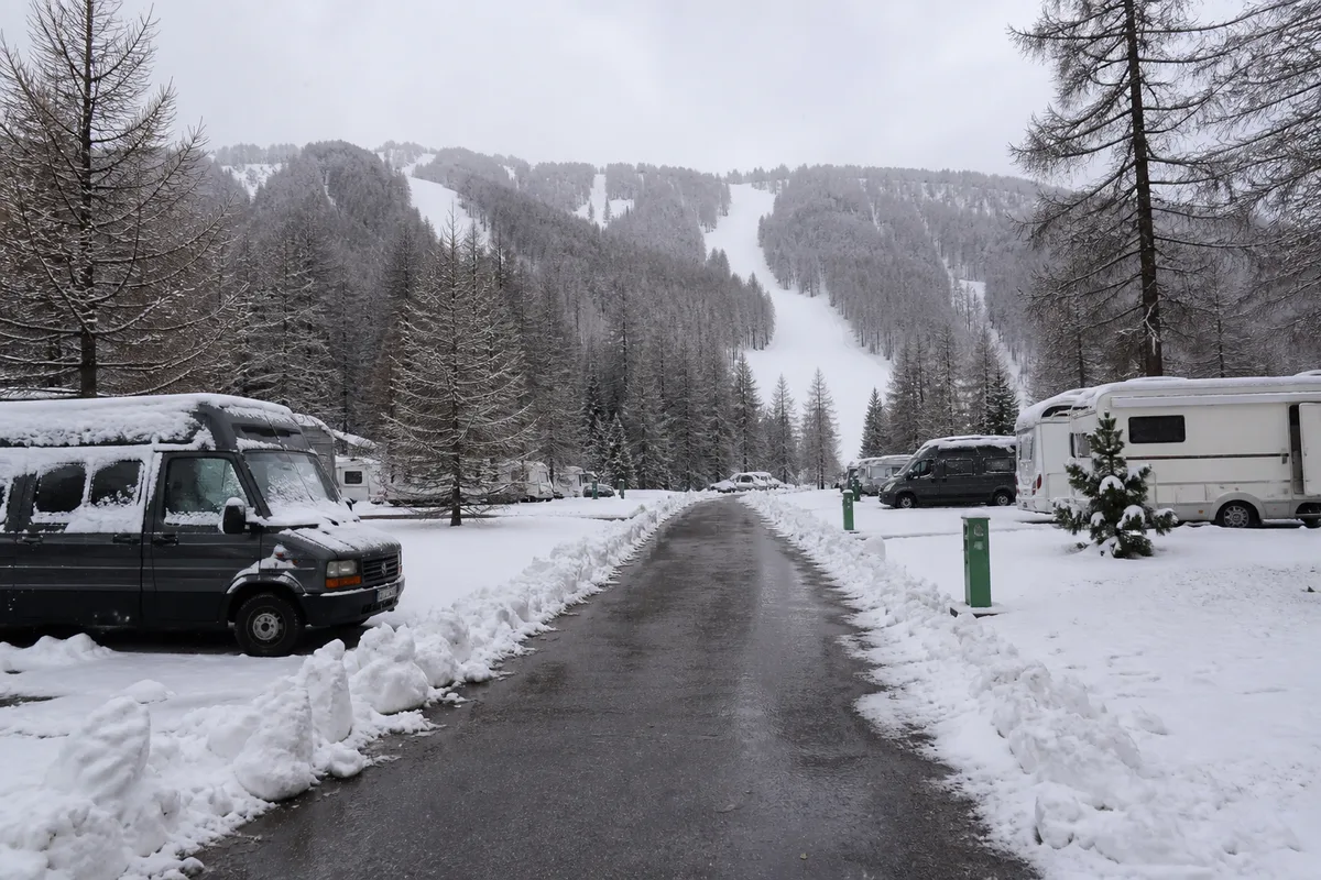 Emplacements de camping déneigés au pied d&rsquo;un versant enneigé